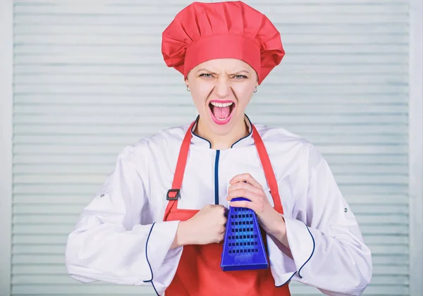 cook in restaurant, uniform. girl in apron and hat. professional chef cooking in kitchen. angry woman loves cooking food with grater. Kitchen utensils. culinary cuisine. Cooking with passion