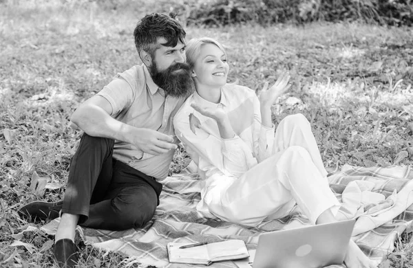 配有笔记本电脑的夫妇可以放松自然环境。家庭享受放松的自然背景。一对留胡子的男人和金发女人坐在绿草草地上放松自然。放松和灵感的概念 — 图库照片