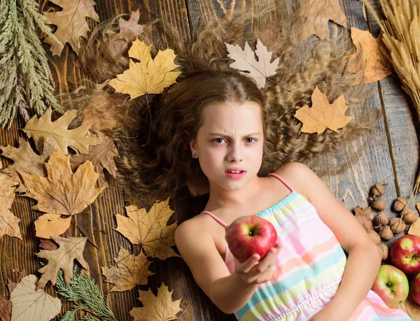 Ένα ξινισμένο μήλο. Χαριτωμένο κορίτσι παιδί με ώριμες φθινοπωρινές σοδειές. Ένα κοριτσάκι που κρατούσε μήλο. Στο μικρό κορίτσι αρέσει η γεύση από φρούτα μήλου. Βιταμίνη τροφή για υγιή ανάπτυξη. Βιολογικά και φυσικά τρόφιμα για την υγεία των παιδιών — Φωτογραφία Αρχείου