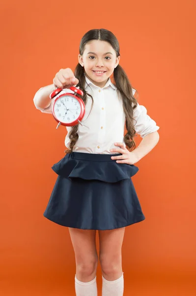 Počáteční lekce. čas jít do školy. Školní čas. Šťastná dívka drží budík na čas oběda. Dětská výchova. Den poznání. každodenní rutinní plán. školka a retro budík — Stock fotografie
