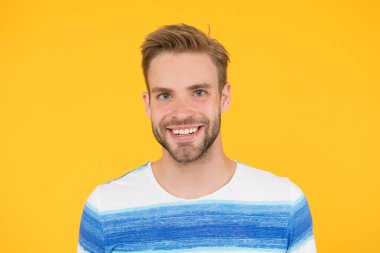 Olumlu duygular. Sarı arka plandaki mutlu adam. Sakallı adam gülümsüyor. Bıyıklı ve sakallı, mutlu yüz ifadesi olan adam. Mutluluk kavramı. Psikolojik sağlık. Mutlu duygusal adam yakın