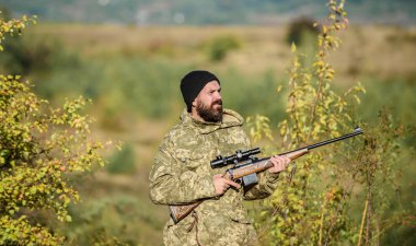 Avcılık erkeksi hobi. Adam acımasız gamekeeper doğa arka plan. Hunter tüfeği tutuyor. Sakallı avcı boş zamanlarını avlayarak geçirir. Odak ve deneyimli avcı konsantrasyonu. Avcılık ve yakalama mevsimleri