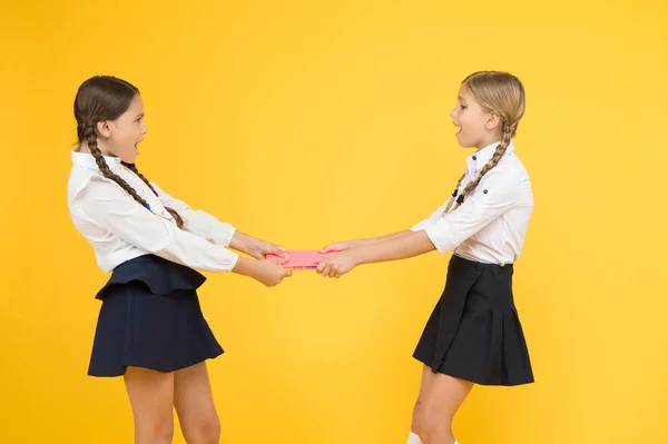 Protect property. Greedy friends. Greedy competitors. Jealous friend. Greedy kids concept. Sisters relations issues. Share book with friend. Classmates rivalry problem. Schoolgirls fight for book — Stock Photo, Image