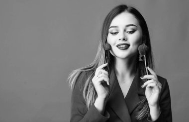 Makyaj fırçası uygulayan çekici kadın. Mükemmel cilt tonu. Makyaj sanatçısı kavramı. İyi görünmek ve kendinden emin hissetmek. Profesyonel makyaj malzemeleri dükkanı. Makyaj kursları. Muhteşem bayan kırmızı dudaklar makyaj