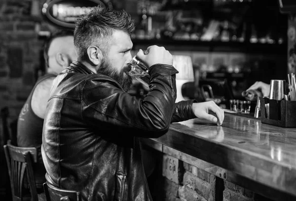 Beställa alkohol dryck. Bar är avkopplande plats har drink och koppla av. Mannen med skägg tillbringa fritiden i mörka bar. Hipster avkopplande på bar med öl. Brutala hipster bearded man sitter på bar counter dricka öl — Stockfoto