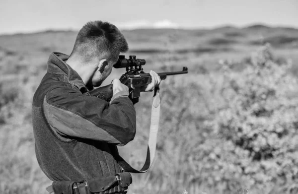 Hunter sostiene el rifle apuntando. En mi objetivo. Cazador barbudo pasar tiempo libre de caza. Equipo de óptica de caza para profesionales. Brutal pasatiempo masculino. Hombre apuntando a fondo la naturaleza objetivo. Apuntar a habilidades — Foto de Stock