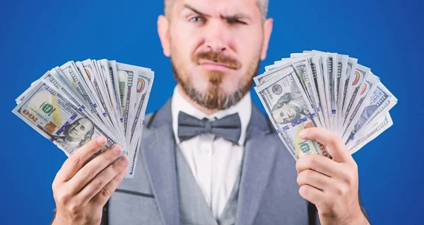 Take my money. Gain real money. Richness and wellbeing concept. Cash transaction business. Easy cash loan. Man formal suit hold many dollar banknotes blue background. Businessman got cash money
