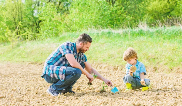 rich natural soil. Eco farm. happy earth day. Family tree. new life. soils and fertilizers. small boy child help father in farming. father and son planting flowers in ground. earth day. Garden bed