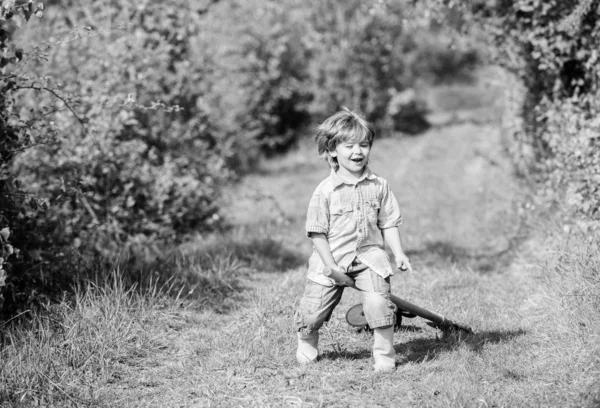 小さな子供はシャベルで遊ぶ。エコロジーと環境保護。地球の日。農業機器。夏の楽しみ。幸せな子供の庭師。春の田舎側の村。楽しみを持っている小さな子供。自然と人間 — ストック写真