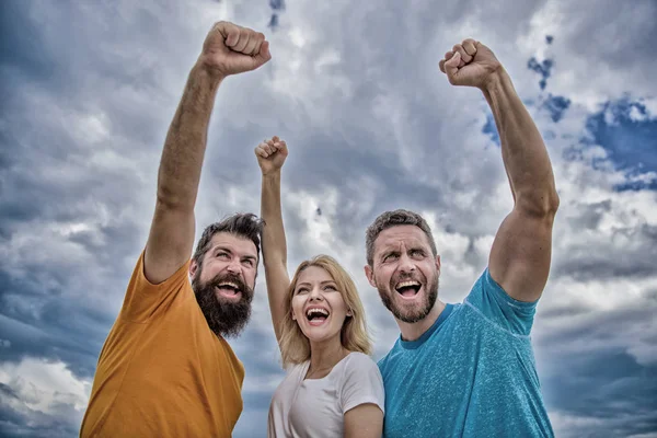 We can do it. Woman and men look successful celebrate victory sky background. Threesome stand happy with raised fists. Behaviors of winner team. Celebrate success. Ways to build successful team