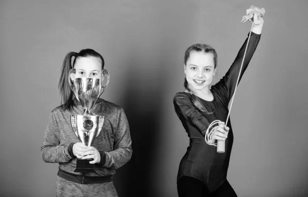 Happy children with gold champion cup. victory of teen girls. Winners in competition. Acrobatics and gymnastics. Little girls hold jump rope. Sport success. they are new champions. I am the champion