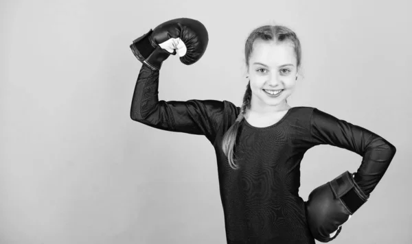 Να είσαι δυνατός. να χτυπάς νοκ-άουτ. Παιδική ηλικία. προπόνηση από μικρό κορίτσι μποξέρ. Αθλητική επιτυχία. αθλητικά ρούχα. Δίαιτα γυμναστικής. την ενεργειακή υγεία. Ευτυχισμένο παιδικό σπορ με γάντια του μποξ. Δύναμη και κίνητρο — Φωτογραφία Αρχείου