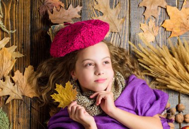 Örme şapka kız sevimli çocuk ahşap arka plan düşmüş akçaağaç üst görünümü bırakır yatıyordu. Moda şapka trendi sonbahar sezonu. Çocuk kız parlak yumuşak örme şapka sonbahar tadını çıkarın. Sonbahar moda şapka aksesuarı