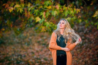 Kız sevimli sarışın sıcak ve rahat kıyafeti sonbahar doğa arka plan defocused poz. Sonbahar için rahat rahat kıyafetler. Hafta sonu için rahat kıyafet fikirleri. Kadın gün batımı ışık yürümek. Her gün için giyim