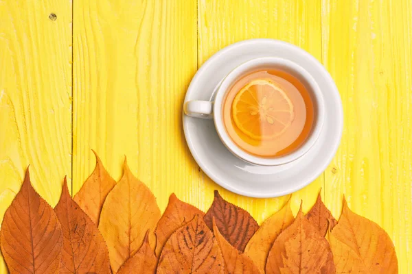 Theekopje met droge bladeren die herfstsamenstelling maken — Stockfoto