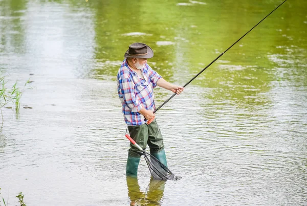 Pescatore in pensione. Uomo anziano che cattura pesce. Uomo maturo che pesca. Tempo libero maschile. Pescatore con canna da pesca. Attività e hobby. Pesca d'acqua dolce lago stagno fiume. La felicità è la verga nella tua mano — Foto Stock