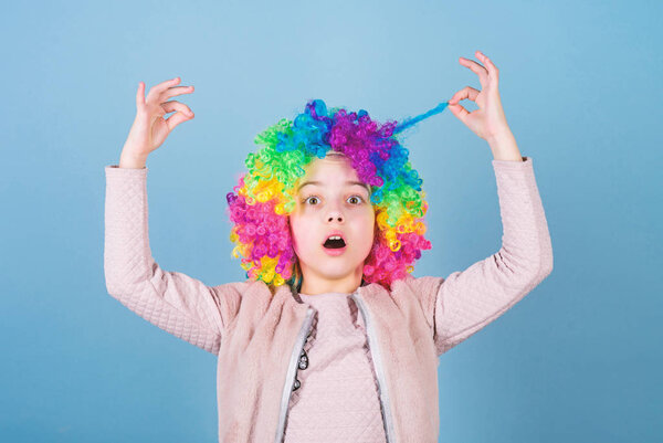 I am an artist and hair is my canvas. Cute little girl with fancy hair. Adorable small child wearing bright clown hair wig. Funny kid with curly synthetic hair