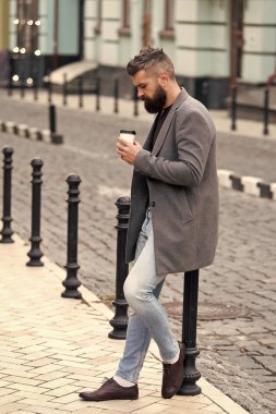 Yürümek ve taze sıcak kahve keyfini çıkarın. Biri sokakta bekleniyor. Adam hipster içki kahve kağıt bardak sakallı. İyi bakımlı işadamı kahve arası açık havada kentsel arka plan tadını çıkarın. Kahve zaman zevk