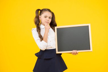 Eğitim hakkında bilgi alın. Küçük çocuk sarı arka plan üzerinde eğitim için boş tahta tutan. Zorunlu ilkokul eğitimi. Reklamcılık eğitimi kursu, kopyalama alanı