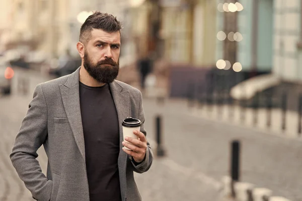 Az ember szakállas csípő ital kávé papírpohár. Jól ápolt üzletember élvezze a kávé alkalom szabadban városi hátterű. Inkább a kávé-on megy. Átgondolt, de nyugodt. Önálló gondot. Finom ital — Stock Fotó