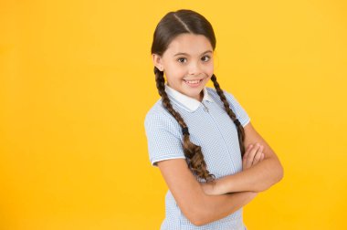 Bilgisine güveniyor. Okul dersi. Çalışma için ilham. Okula geri dön. Bilgi günü. Liseli kız çalışmaktan hoşlanır. Çocuk okul üniforması. Gülümseyen cutie geçti eller sarı arka plan kopyalama alanı