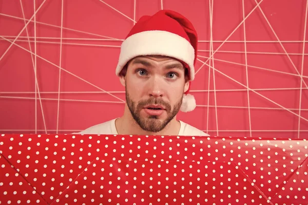 サンタはあなたのためのギフトを持って来る。男の魅力的なサンタ クロースは、大きな箱を運ぶ。クリスマス プレゼント交換。クリスマスの休日のお祝い。男ハンサムなひげを剃っていないサンタ帽子は、ギフト ボックスを保持します。クリスマス ギフトの概念 — ストック写真