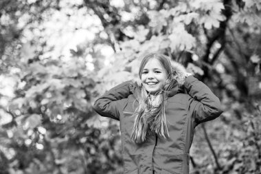 Sıcak ceketle rahat hissediyorum. Kız mutlu giyim ceket kukuleta ile sonbahar doğa keyfini çıkarın. Çocuk giyim ceket sonbahar sezonu için. Giyim Sonbahar ve kavram moda. Yürüyüş çocuk sarı uzun saçlı düşmek park arka plan