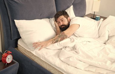 Ne korkunç gürültü. Sorun sabah erken uyanma. Çalar saat ile kaldırın. Yine uyuya kalmışım. Erken uyanma için ipuçları. Adam hipster uykulu yüz yatak çalar saat ile sakallı. Bu zil açmak