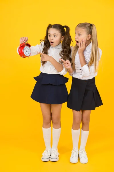 O Latecomer será punido. Está na hora. Horário escolar. Hora da escola. Alunas e despertador. Alunos de escola de crianças. Dia do conhecimento. Surpreendido crianças chocadas segurar despertador tempo de contagem — Fotografia de Stock