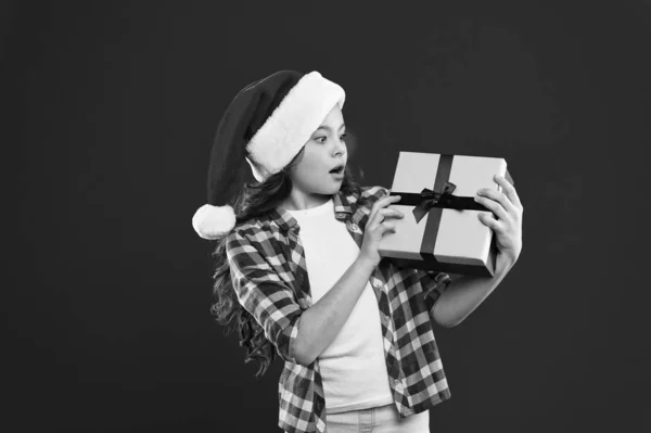 J'attends l'émerveillement. Les courses de Noël. Fête du Nouvel An. Le petit Père Noël. Joyeuses vacances d'hiver. Petite fille. Présent pour Noël. Enfance. Petite fille enfant en chapeau rouge Père Noël — Photo