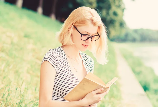 Ispirato da un autore di romanzi. Storia interessante. Rilassati e ottieni nuove informazioni. donna nel parco a leggere un libro. La lettura è il mio hobby. Studio estivo. studentessa con libro all'aperto. tenuta libro di lezioni — Foto Stock