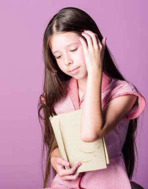 Küçük kız okumayı öğrenir. Evde eğitim konsepti. Bilginin susuzluğu. Çok güzel bir kitap kurdu. Edebiyatı hobi olarak okumak. Kurgu ve kurgu dışı. Mor arka plan sevimli küçük çocuk okuma kitabı