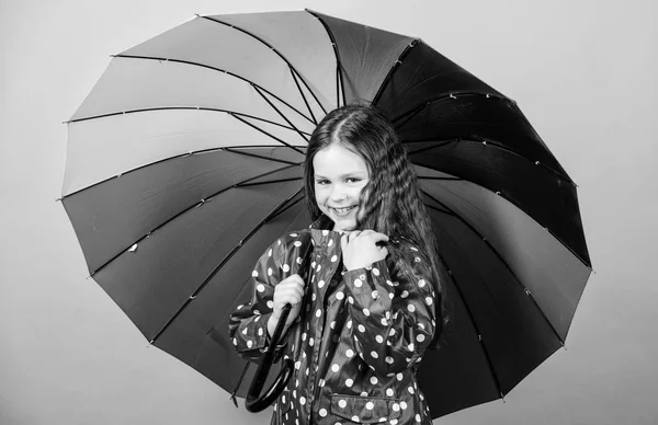 cheerful hipster child in positive mood. rain protection. Rainbow. happy small girl with colorful umbrella. Small girl in raincoat. autumn fashion. Feeling the nature. So beautiful