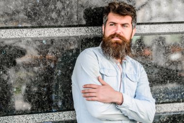 Uzun sakallı erkeksi bir görünüm. Berber konsepti. Sakal tımarı. Sakal bakımı. Adam çekici sakallı hipster açık havada poz. Erkeklik ve erkeklik. Yakışıklı adamın kendine güvenen duruşu