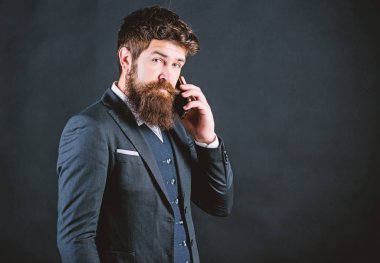Teknoloji her zaman iş yerinde ona yardımcı olur. Sakallı olgun hipster telefonda konuşuyor. bıyıklı vahşi kafkas hipster. takım elbiseli iş adamı. çevrimiçi ve çevik. Akıllı telefon ile sakallı adam