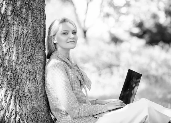 Work outdoors benefits. Woman with laptop work outdoors lean tree. Minute for relax. Girl work with laptop in park sit on grass. Education technology and internet concept. Natural environment office