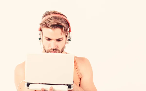 寻找最喜欢的音乐。性感肌肉男人听录音。戴耳机的男人被白色隔离。电子书。没刮胡子的人在听有声读物。使用笔记本电脑和耳机。复制空间 — 图库照片
