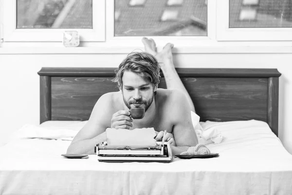 Morning inspiration. Erotic literature. Daily routine of writer. Man writer lay bed with breakfast working. Writer handsome author used old fashioned manual typewriter. Morning bring fresh idea