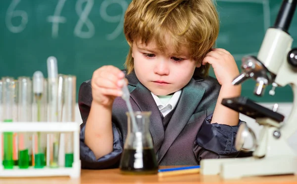 Wissenschaftskonzept. Hochbegabtes Kind und Wunderkind. Kinder studieren Chemiestudium. Schulbildung. Erforschung biologischer Moleküle. Kleinkind Genie Baby. Junge in der Nähe von Mikroskop und Reagenzgläsern im Klassenzimmer — Stockfoto