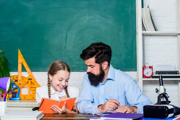 Chica caprichosa. estudio de la hija con padre. Día del maestro. educación desarrollo infantil. de vuelta a la escuela. Día del conocimiento. Enseñanza en casa. barbudo hombre profesor con pequeña chica en el aula —  Fotos de Stock