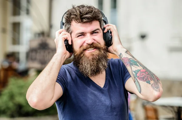 Man bearded hipster headphones listening music. Excellent music playlist. Hipster enjoy excellent sound song in earphones. Walking with music. Music beat for energetic mood. Rhythm for walk