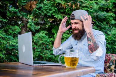Bira zor bir günün ardından rahatlamasına yardımcı olur. Bira ve dizüstü bilgisayar ile acımasız adam eğlence. Sonunda Cuma. Hipster rahatlayın bira eşliğinde terasta oturun. Sakallı hipster freelancer bira kupa ile iş günü sonunda zevk