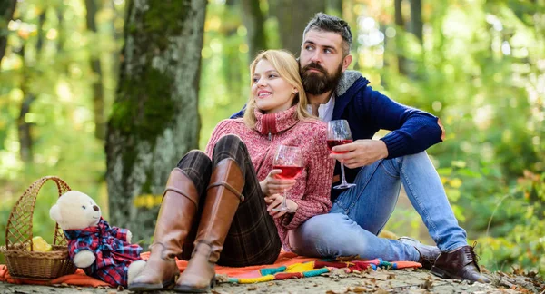 Disfrutando de su cita perfecta. Feliz pareja de amor relajándose en el parque juntos. Picnic romántico con vino en el bosque. Pareja enamorada celebra la cita de picnic de aniversario. Pareja abrazando beber vino — Foto de Stock