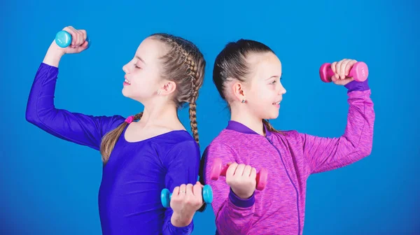 Happy children coach with barbell. Fitness diet for energy health. workout of small girls hold dumbbell. weight lifting for muscules. Childhood activity. Sport success. planning time with coach