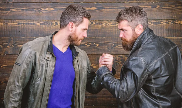 Hombres barbudos brutales usan chaquetas de cuero estrechando las manos. Un fuerte apretón de manos. Amistad de tipos brutales. Símbolo de apretón de manos de acuerdo exitoso. Trato de negocios aprobado. Gestos de apretón de manos. Han acordado —  Fotos de Stock