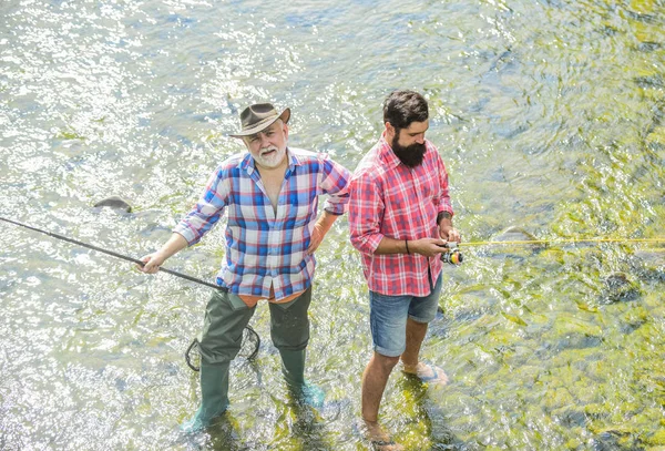 Erkekler sakallı balıkçılar. Hafta sonları balık tutmak için yapılmış. Aktif güneşli bir gün. Balıkçılar balıkçılık ekipmanları. Hobi spor aktivitesi. Balıkçı arkadaşlar nehirde duruyor. Balıklar normalde vahşi doğada yakalanır. Yaz eğlence — Stok fotoğraf
