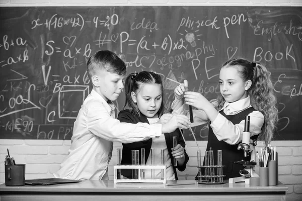 Studenten machen biologische Experimente mit dem Mikroskop. Chemie-Mikroskop. Labormikroskop. Kindertag. Kleine Kinder lernen Chemie im Schullabor. Kleine Kinder im Labor. Tödlich und gefährlich — Stockfoto