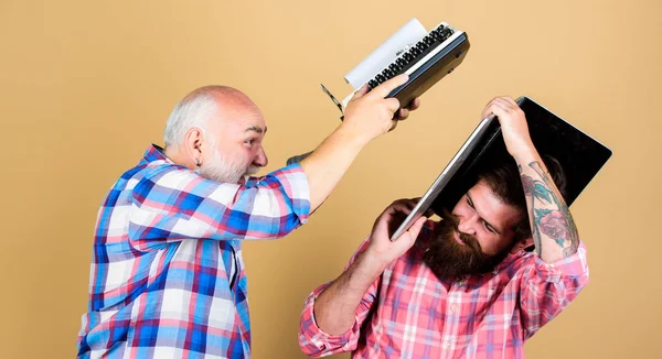 Confrontation. technology battle. Modern life. youth vs old age. business approach. father and son. family generation. two bearded men. Vintage typewriter. retro typewriter vs laptop. New technology — Stock Photo, Image