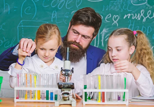 Man bearded teacher work with microscope and test tubes in biology classroom. How to interest children study. Explaining biology to children. Fascinating biology lesson. School teacher of biology