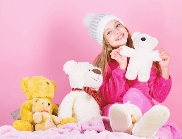Kid little girl play with soft toy teddy bear on pink background. Toy every child dreaming. Happy childhood concept. Child small girl playful hold teddy bear plush toy. Why kids love stuffed animals